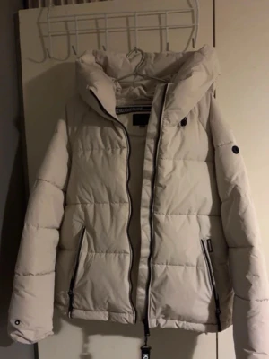 Vit dunjacka  - Säljer min vita dunjacka i fint skick, obs liten i strl så mer som en L.  Säljer pga att jag har en annan vinterjacka och får därför aldrig användning för denna tyvärr.