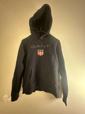 Gant hoodie - Mörkblå ganthoodie, ej storleksmärkt men tippar på ca 150. Välanvänd men ändå ok.