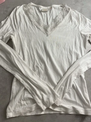 Vit långärmad spetsblus Gina Tricot🤍 - Supersöt vit långärmad blus från Gina Tricot med v-ringning dekorerad med spetsdetaljer. Tillverkad i mjuk bomull som känns skön mot huden. Perfekt att styla med jeans eller kjol för en fräsch look.
