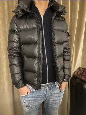 Svart Moncler pufferjacka med huva - Tja! Säljer en svart pufferjacka från Moncler i storlek M~S/ modellen är 1.80 En väldigt liten defekt framtill högra bröstet samt vid bakdelen av jackan( som visas på bilderna). Annars i väldigt fint skick. Säljer för ett relevant pris. Självklart äkta. Kvitto tillkommer/Dma💥