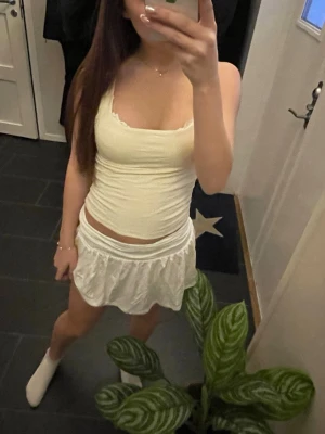 Vit kortkjol med volang - Säljer en supersöt vit kortkjol med volangkant och bred midjeresår! Perfekt till vår/sommar och enkel att stylea med olika toppar❣️den är storlek XXS men är väldigt stretchig så passar XS-S💕helt oanvänd, nypris 270kr!!