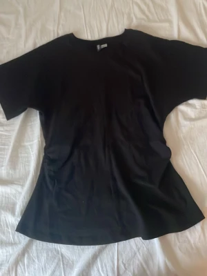 Svart t-shirt från H&M Divided XS - Enkel svart t-shirt från H&M Divided. Den är lite tajtare vid magen och sen blir den vidare. Pris kan diskuteras. Helt oanvänd.