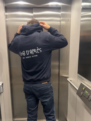 CLUB D’APRÈS Hoodie - Club d’Après - den perfekta hoodien för afterski, stadsliv och allt däremellan. Simpel, mjuk och stilren. 