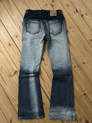 Black Premium bootcut jeans blå - Bootcut jeans från Black Premium i en cool tvättad blå färg med mörka och ljusa partier. Materialet är jeans med snygga kontrastsömmar och lite detaljer på bakfickan. Säljer då dem inte kommer till användning. Midjemått = 35.50 cm Innerbenslångden = 81 cm.