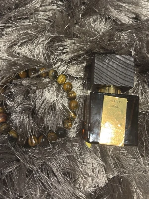 Elegant parfym med gulddetalj + snyggt armband på köpet - Stilren parfymflaska med exklusiv guldfärgad etikett och mörkt lock. Perfekt för dig som vill sticka ut med en lyxig accessoar på hyllan. Mörk kryddig sexig doft perfekt för dejt eller en kväll ute.Aldrig andvänd pris kan diskuteras!