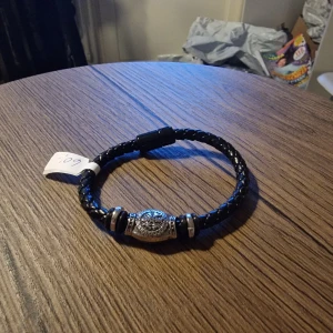 Armband viking i konstläder. - Armband viking i konstläder. 21 cm lång. Bredd 1,3 cm. Magnet spänne.