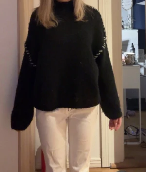 Svart stickad polotröja med detaljer - Svart stickad tröja med vita sömdetaljer längs axlarna. Endast använd ett fåtal gånger så är i väldigt bra skick!!!🩷🩷