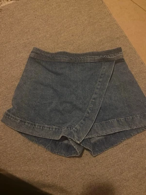 Jeansskorts med inbyggd shorts  - Snygga blå jeans kjol med inbyggt shorts , aldrig använd , köpt på hm 