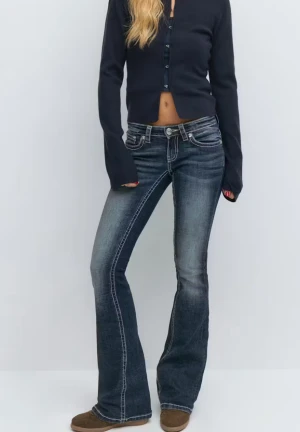 Blå bootcut jeans med broderade fickor - Säljer ett par mörkblå bootcut jeans med snygga kontrastsömmar och broderade bakfickor. Jeansen har låg midja och klassisk femficksdesign. Materialet är slitstarkt denim och passformen är riktigt skön med lite utsvängda ben. Storlek s i tall