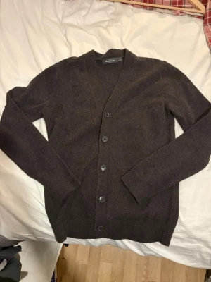 Brun kofta från Dressmann i ull - Brun kofta från Dressmann i mycket fint skick. Klassisk modell med bra passform, mjukt material och inga tecken på slitage. Perfekt som vardagsplagg eller lager på lager. Den är redo att skickas direkt och kommer gå snabbt – köp nu innan någon annan tar den ✅Beställ nu = Framme innan Jul ✅Ställ frågor = Snabba svar