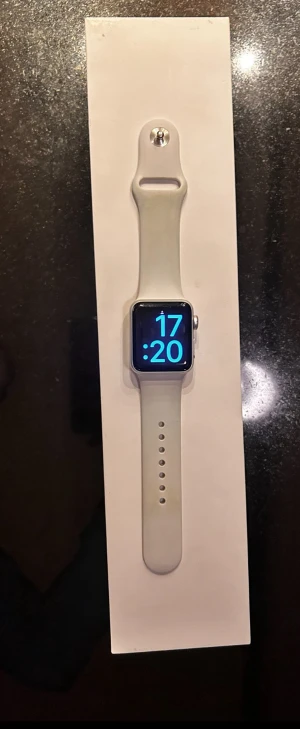Apple Watch Series 3 - Apple Watch Series 3 med vit sportarmband och originalförpackning. Klockan har GPS och LTE, fungerar bra. Laddkabel medföljer. Batteriets maxkapacitet är 90%. Storlek 38 mm, är köpt 2022 och är i fint skick. Original pris 2490 kr