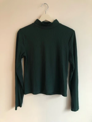 Mörkgrön tröja - Grön ribbad tröja med halvpolo från Lindex. I nyskick, använd några fåtal gånger.  