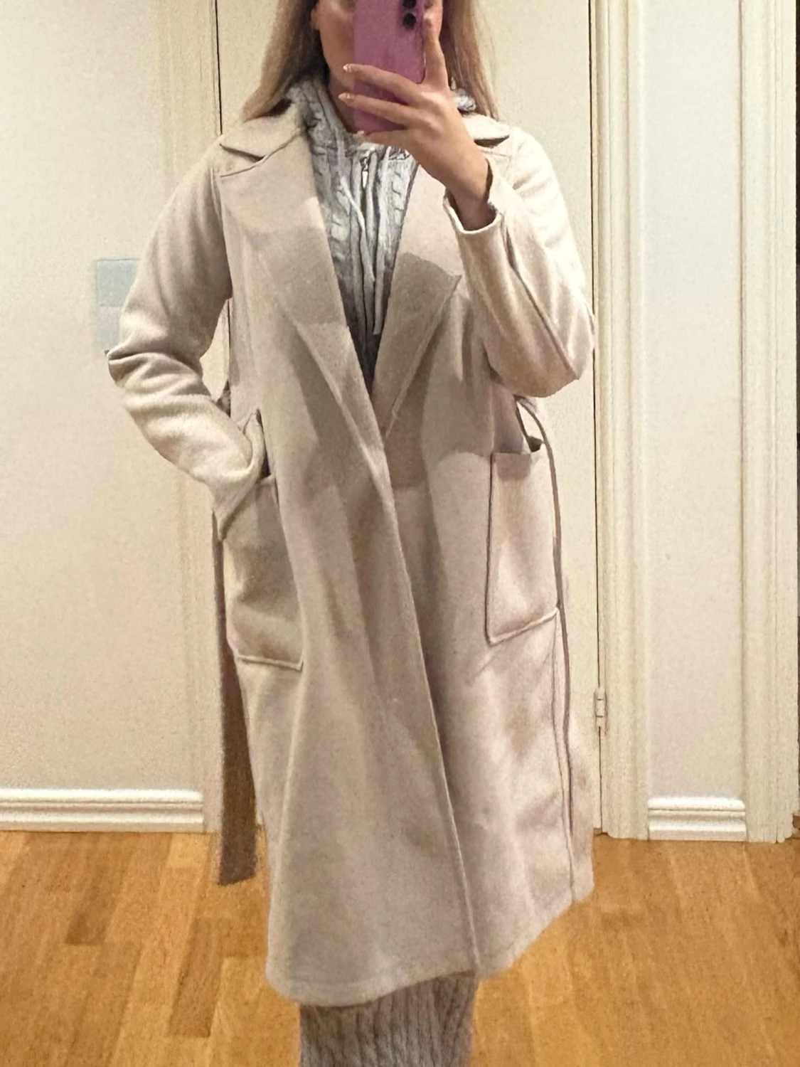 Beige kappa med bälte och stora fickor