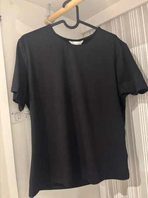 Svart idrotts tröja  - Köpt för 150kr. Enkel svart idrotts tröja med rund hals och korta ärmar. Väldigt bra för svett, perfekt för en clean och stilren look. Passformen är normal och modellen är klassisk utan några tryck eller detaljer.