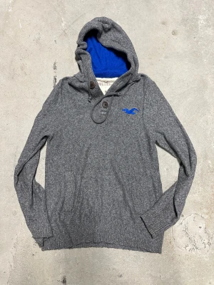 Hollister stickad hoodie med knappar - Extremt eftertraktad och sällsynt  Hollister hoodie som är stickad med knappar! Grymt skick, inga defekter - ser exakt ut som på bild! Storlek M kan passa som S. Skriv vid frågor!💬