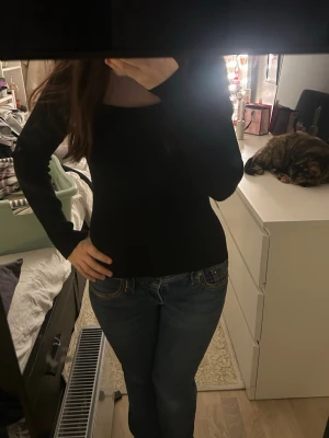 Svart ribbad långärmad topp H&M - Svart långärmad topp från H&M med ribbad struktur och rundad halsringning. Sitter snyggt och har en slim passform som framhäver figuren. Materialet är en mix av polyester, viskos och polyamid vilket gör den mjuk och stretchig. Perfekt till jeans eller kjol.