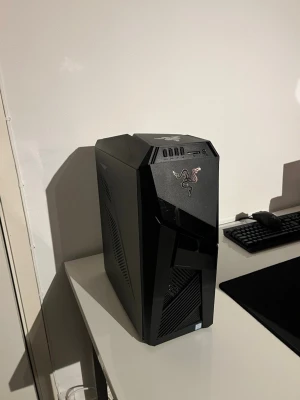 ASUS ROG Stationär Dator i7-8700 GTX1070 - Kraftfull ASUS ROG stationär dator med Intel Core i7-8700, 16GB DDR4 RAM, NVIDIA GeForce GTX1070 8GB, 1TB HDD och 128GB SSD. Utrustad med DVD RW, LAN, WiFi och Bluetooth. Snygg design, mycket bra skick utan synligt slitage.