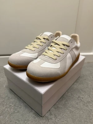 Vita Maison Margiela skor - Tja, säljer dessa vita Maison Margiela skorna i storlek 43. Säljer dem för att dem inte passar. Dem är i nyskick, box och dustbag medföljer vid köp. Hojta till om ni har frågor eller prisförslag!🤩