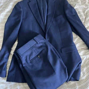 Blå Kostym Riley Stanton 46 - Marinblå kostym av märke Riley, modellen heter Stanton. Storlek 46. Mycket fint skick! Snabb leverans vid köpt vara