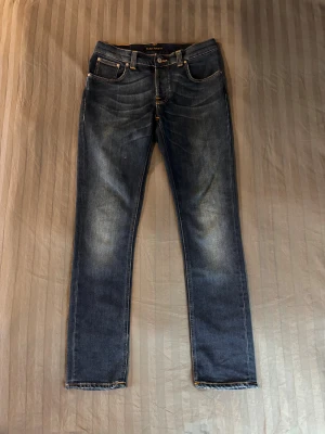 Nudie grim tim slim fit - Tjena säljer ett par nudie jeans med skön wash i modellen grim tim som sitter slim. Storleken är W31 L32. 