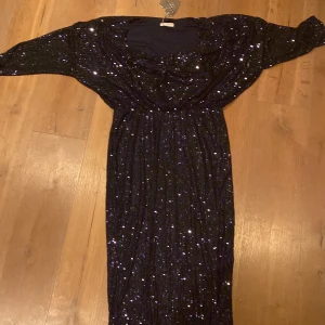 Mörkblå glittrig klänning från Goddiva - Säljer en elegant mörkblå klänning från Goddiva med glittriga paljetter. Klänningen har en cowl neck och är långärmad, perfekt för en festlig kväll. Den är i en smickrande passform som framhäver figuren. Perfekt för att glänsa på nästa event! ✨ord pris 715kr ej använd prislapp kvar 