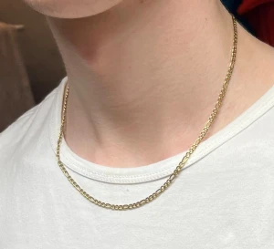 18K guldhalsband med kedja - Snyggt halsband i 18K guld med klassisk kedjedesign. Kedjan har en stilren och tidlös look som passar perfekt till din stil. Märkt med K18 på låset för att visa äktheten. Perfekt för dig som vill ha något exklusivt och enkelt. Pris kan diskuteras.