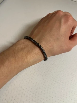 Silverfärgat armband - Snyggt armband i silverfärgad metall med flätad kedja och klassisk låsning. Perfekt för dig som gillar stilrena accessoarer med lite edge. Passar både till jeans och t-shirt eller till en mer uppklädd look.