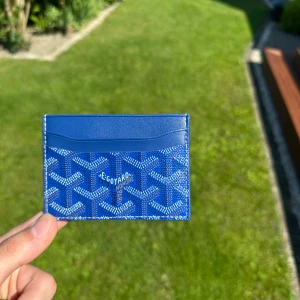 Blå Goyaard korthållare  - Snygg blå korthållare, nytt skick(aldrig använd), kommer med etikett och låda. Skriv om du har några frågor eller andra funderingar!                            Plånboken är i vanlig storlek, den rymmer fyra kort men även här ett mittenfack för sedlar och mynt (PRODUKTEN ÄR FAST PRIS)