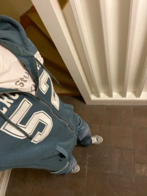 Abercrombie & Fitch Hoodie - Mörkgrön hoodie från Abercrombie & Fitch med dragkedja och huva. Stor broderad text och siffran 52 framtill. Mjuk insida och kängurufickor. Lätt att styla och passar med dem flesta färgerna på jeans. Om du undrar något är det bara att skriva🙌✅