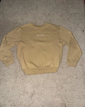 Beige sweatshirt från Vans - Säljer en beige sweatshirt från Vans i storlek medium. Tröjan har relaxed passform, rund hals och långärmade muddade ärmar. Materialet är mjuk bomull med fleece på insidan, perfekt för chill dagar. Vans-logga broderad framtill.