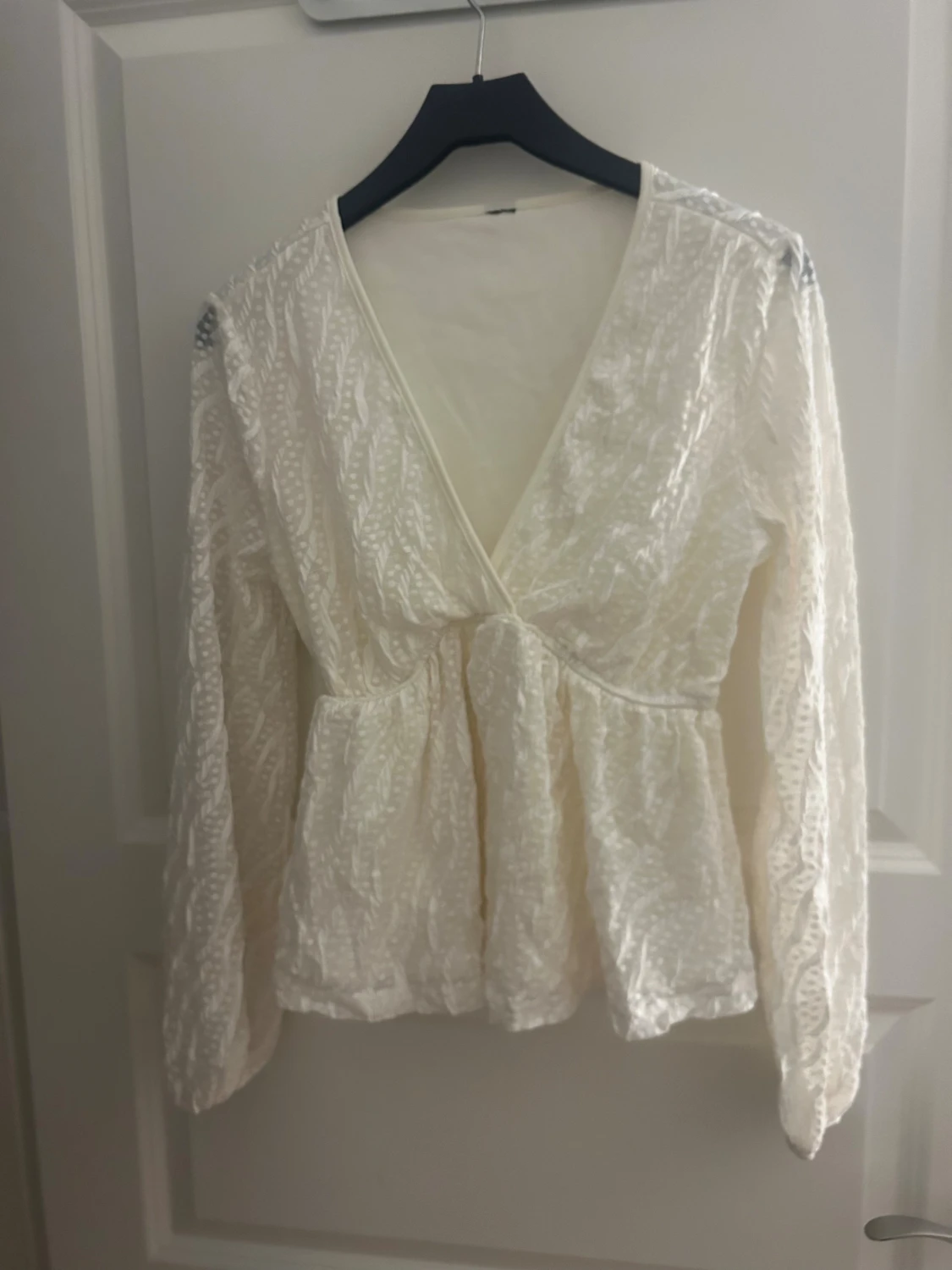 Vit blus med v-ringning och spetsdetaljer