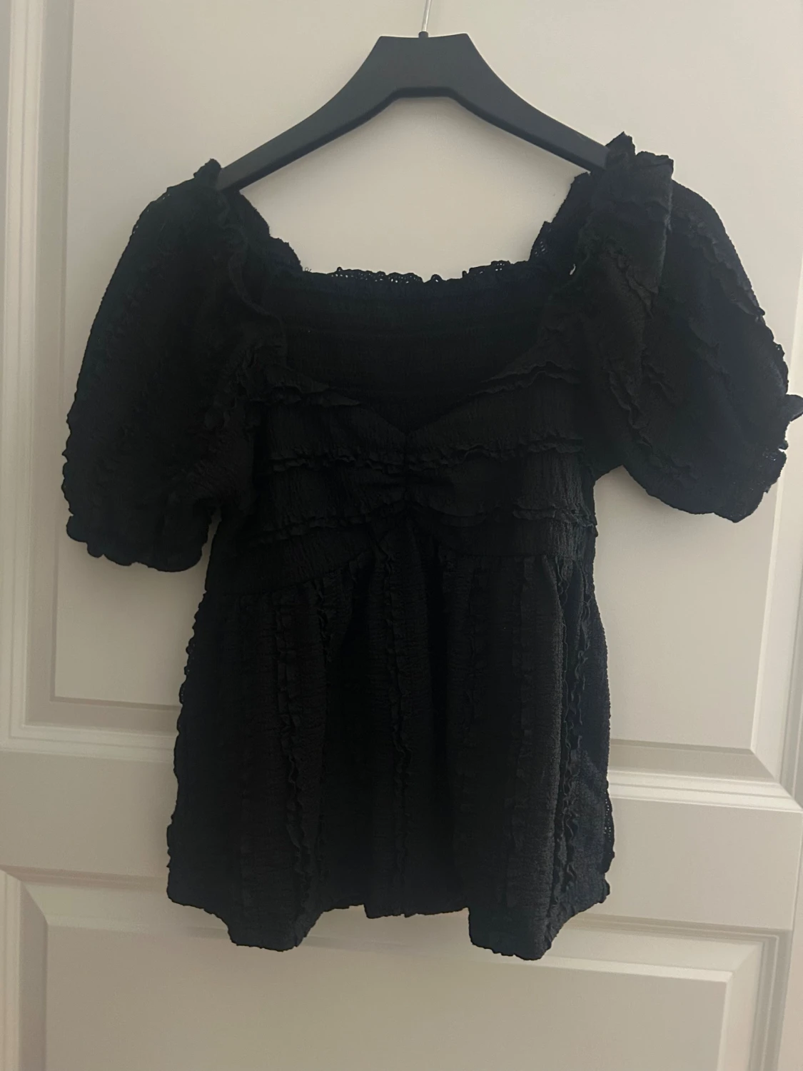 Svart blus med volang och puffärm