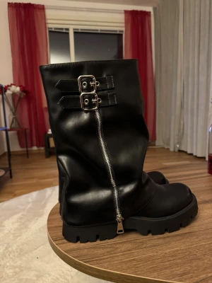 Svarta boots med grov sula och dragkedja - Säljer dessa skor i strlk 39, aldrig använda (endast testade) köpte dessa för 700kr för 3 månader sedan, säljer för 350kr plus frakt. (Priset kan diskuteras vid snabb affär) 