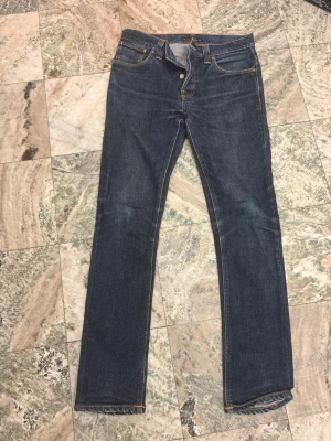 Mörkblåa Nudia jeans - Snygga mörkblå slim fit jeans från Nudie. Modellen Grim trim W33 L34.