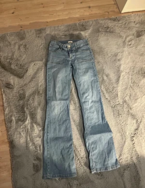 Bootcut jeans från Nelly ljusblå - Jättefina bootcut jeans från Nelly! Lite slitna längst ner som man ser på bilden men annars jättebra skick🫶🏻 strl xs 