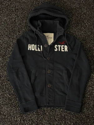 Hollister cardigan - sjukt eftertraktad! - 🔥 Extremt eftertraktad Hollister-hoodie, stl M, skick 8/10 🔥 Black Week-REA! Passa på medan priset är sänkt – det här är en av Hollisters mest populära modeller och den dyker nästan aldrig upp. Sitter perfekt, sjukt snygg och funkar till ALLT.  Den här kommer försvinna direkt – folk brukar köpa såna här på sekunder. Först till kvarn. Köp nu innan någon annan hinner före!  