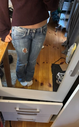 Blå bootcut jeans med slitningar - Säljer mina absolut favorit jeans då dom tyvärr är för små! Dom har gått sönder lite på ena låret framtill även mellan benen och lite bak annars är det inget problem på dom💗💗Köpte dom för ca 700kr