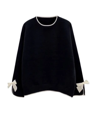 Svart stickad tröja med rosetter - Svart stickad tröja med vita detaljer och söta rosetter vid ärmsluten. Rund halsringning med vit kant och matchande vit kant längst ner. Perfekt för dig som gillar stilrena plagg med en twist.