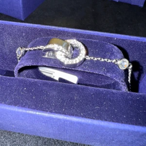 Swarovski silverarmband med kristaller - Ett elegant armband från Swarovski i silverfärg med tunn kedja och justerbar låsning. Mittendelen består av två sammanlänkade ringar, varav en är täckt av gnistrande kristaller. Perfekt för dig som gillar stilrena och glittriga detaljer. Priset är nedsatt då det är Black Week. Vid köp av två eller fler får du dessutom välja en present 🎁❤️ (presenterna kan jag visa i DM eftersom de inte finns upplagda här).