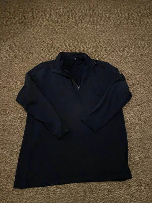 Marinblå half zip tröja Oscar Jacobson - Snygg marinblå långärmad tröja från Oscar Jacobson med half zip och krage. Perfekt för dig som gillar stilrena och klassiska plagg. Materialet känns mjukt och lätt, troligen bomull eller polyester. Passar dig som vill ha en enkel men schysst look.