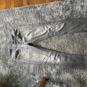 Dondup jeans - Säljer nu mina snygga grå dondup jeans  Färg grå Size 30 Modell George  Fickan på ena sidan har gått up lite men inget som syns jättemycket. Har lagat dom i skrevet också men börjar få lite slitningar där med