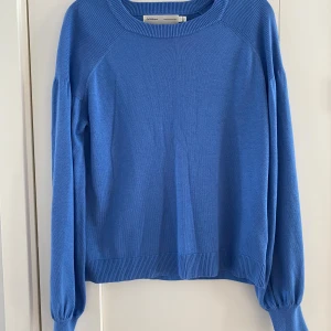 Blå stickad tröja från InWear - Snygg blå stickad tröja från InWear med rund hals och ribbade muddar. Tröjan har långärmade puffärmar och är tillverkad i mjukt material som känns skönt mot huden. Perfekt för dig som gillar stilrena och bekväma plagg.                                      Mått Över bröstet: ca 51 cm Längd från axeln och ner: ca 58 cm  Material: 65% polyester och 35% viskos  Kommer från ett djur- och rökfritt hem. 