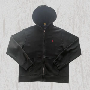 Ralph lauren zip  - Svart Ralph Lauren Tröja - Bra Skick!  Beskrivning: Säljer en snygg svart Ralph Lauren tröja i storlek L (14-16 år), men den sitter som en small/x small i vanlig storlek. Den är i bra skick och har använts varsamt. Perfekt för en stilren och avslappnad look.  Detaljer:  *   Storlek: L (14-15 år) - sitter som Small *   Skick: Bra skick *   Färg: Svart *   Märke: Ralph Lauren *   Material: Bomull  Pris: [Pris] kr (Kan diskuteras)