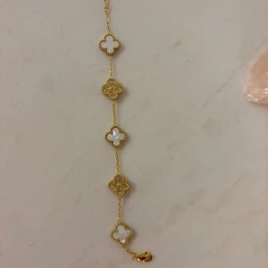 Guldigt inspirerat armband med fyrklöver (ej äkta) - Snyggt armband i guld, oanvänt.