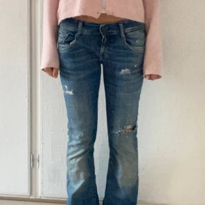 Replay bootcut jeans med slitningar - Ett par replay jeans med hål i sig som är bootcut low rise