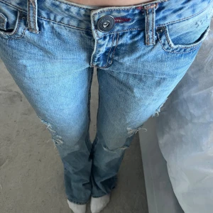Ljusblå lågmidjade jeans - Säljer ett par ljusblå bootcut, lågmidjade jeans från aérostaple. De står ingen direkt storlek på jeansen men de skulle passa 38. Säljer dessa jeans pågrund av för stor storlek. Jeansen är slitna längst ner pga att de har varit för långa för mig.😊