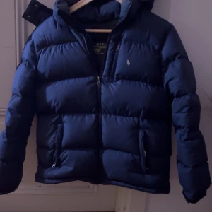 Mörkblå dunjacka Polo Ralph Lauren - Säljer nu denna marinblåa Ralph lauren jacka då jag inte använder den längre, köpt för 2000 och är jättebra skick. Storlek L (14-16). Billigare vid snabb affär💕💕