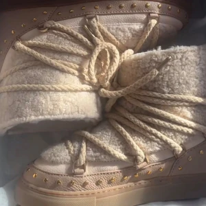 Beige inukii med guld detaljer  - Super fina vinter skor som värmer och skyddar från vatten. Storlek 40 men passar mig bra som bör 38 i vanliga fall. Storleken är väldigt passande och passar 38-40 🥰  Köpta för 4000kr från Inuikii själva, under februari 2025. Alltså hyfsat nya 💕  Sparsamt använda men de är använda 💓  Tecken på användning syns bara lite i sulan, inga andra stora defekter !