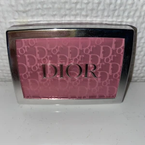 Dior Rosy Glow 001 Pink Rouge - Dior Rosy Glow i nyansen 001 Pink är ett puderrouge i en klar, kallrosa färg. Kommer i en lyxig transparent och silverfärgad ask med spegel. Perfekt för att ge kinderna en fräsch och naturlig glow. Klassisk Dior-logga på locket.