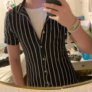 Blå/vit randig piké med knappar  - Jag säljer den här super snygga randiga pikén som jag köpte utomlands! Den sitter slim som storlek s/m ungefär och perfekt på dig som är runt 178-180 hållet! Den passar perfekt inför fest eller till våren/sommaren! Hör av er vid intresse😇